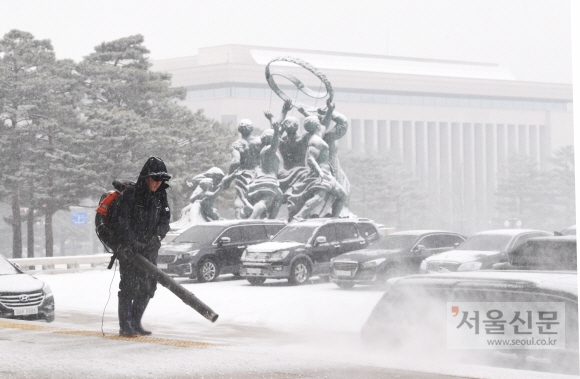 눈이 내린 13일 국회에서 직원들이 눈을 치우고 있다. 2018.12.13.  김명국 선임기자 daunso@seoul.co.kr.