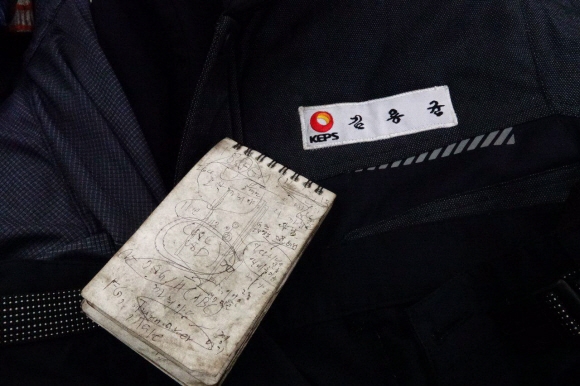 석탄가루가 잔뜩 묻은 김씨의 작업복과 수첩.  전국공공운수노조 제공
