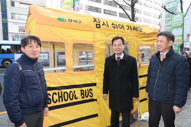 박겸수(가운데) 서울 강북구청장이 19일 수유역 버스정류장에 설치한 따숨터를 찾아 한파 예방시설을 점검하고 있다.  강북구 제공