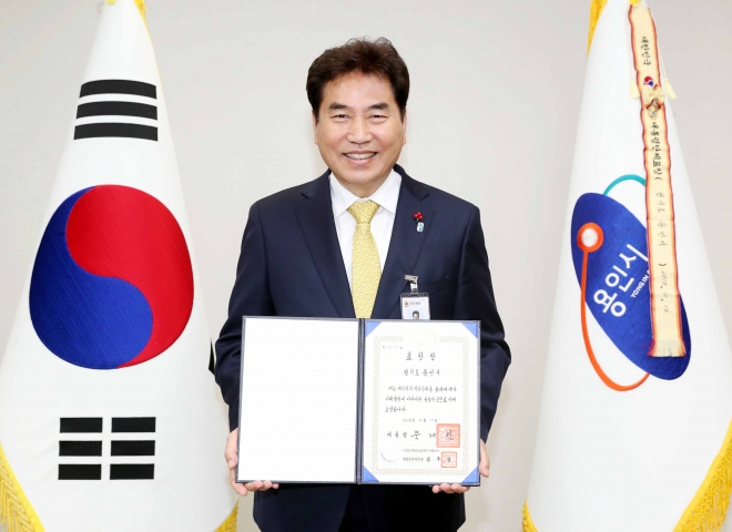 백군기 용인시장이 대통령 표창장을 받고 환하게 웃고 있다.