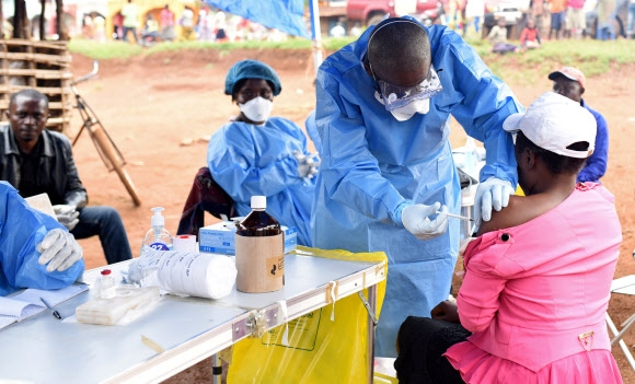 현지 보건당국 관계자가 지난 8월 콩고민주공화국 북부의 한 마을에서 에볼라 감염자와 접촉해 감염 우려가 있는 한 여성에게 에볼라 바이러스 백신 접종을 하는 모습. 로이터연합뉴스