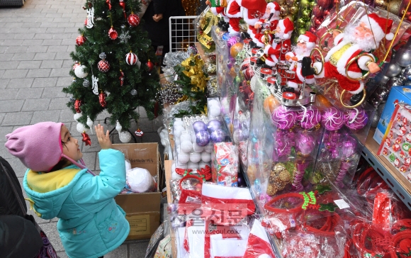 크리스마스를 이틀 앞둔 23일 오전 서울 남대문시장을 찾은 어린이가 산타인형에게 인사하고 있다. 2018.12.23. 도준석 기자 pado@seoul.co.kr