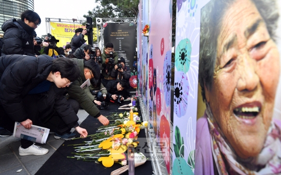 26일 서울 종로구 옛 일본대사관 앞에서 열린 ‘일본군 성노예제 문제 해결을 위한 제1367차 정기 수요시위’에 참가한 시민들이 김복득 할머니 등 올해 세상을 떠난 피해 할머니 8명의 영정 앞에 장미꽃을 내려놓으며 고인의 넋을 기리고 있다. 박윤슬 기자 seul@seoul.co.kr