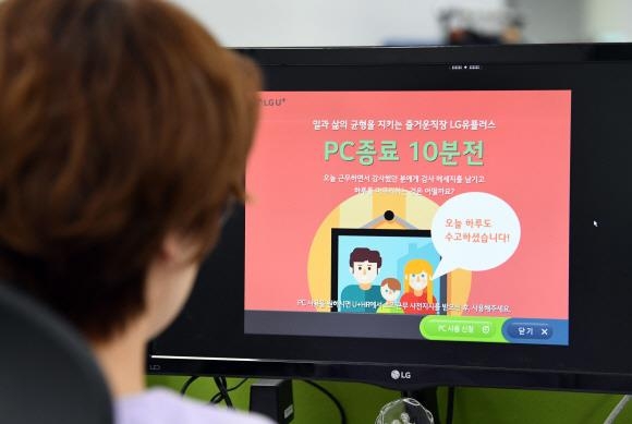 한 직원의 컴퓨터 모니터에 PC 종료 10분 전이라는 알림창이 떠 있다.  서울신문 DB