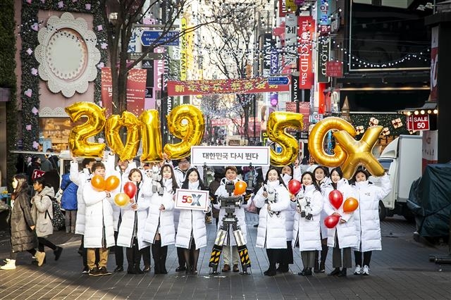 SK텔레콤 신입사원들과 로봇 ‘똘망’이 서울 중구 명동에서 희망찬 한 해를 기원하며 ‘대한민국 다시 뛴다’는 메시지를 들어 보이고 있다.  SK텔레콤 제공