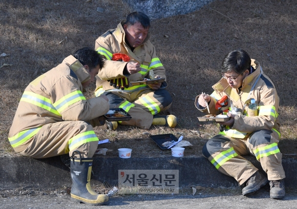 2일 강원도 양양군 서면에서 산불이 발생한 가운데 의용소방대원들이 화재현장 인근에서 잔불을 진압 후 늦은 점심을 먹고 있다. 2018.1.2  박지환 기자 popocar@seoul.co.kr