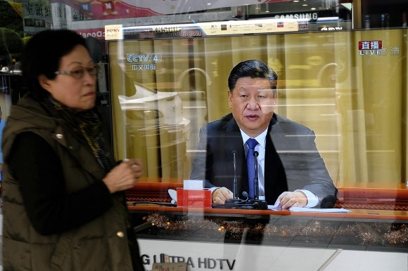 한 대만 시민이 2일 신베이시에서 ‘대만 동포들에게 알리는 글’ 발표 40주년 기념대회에서 연설하는 시진핑 중국 국가주석의 TV 중계 화면 앞을 지나치고 있다.  신베이 AFP 연합뉴스