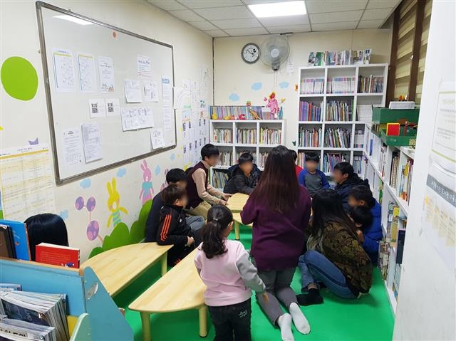 서울 구로구 온수동에 위치한 마중물도서관에서 운영되는 ‘온종일 돌봄센터’에서 지역 아동들이 둘러앉아 담당 교사와 함께 이야기하고 있다. 구로구 제공