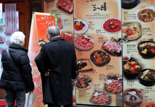 시민들이 거리에 세워져 있는 메뉴판을 살펴보고 있다.  연합뉴스 자료사진