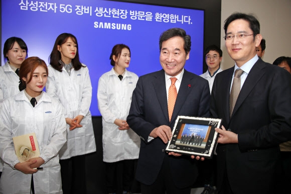 10일 경기 수원시 삼성전자 5G 장비 생산 현장을 방문한 이낙연(오른쪽 두 번째) 국무총리와 이재용(오른쪽) 삼성전자 부회장이 기념사진을 들고 미소 짓고 있다.  연합뉴스