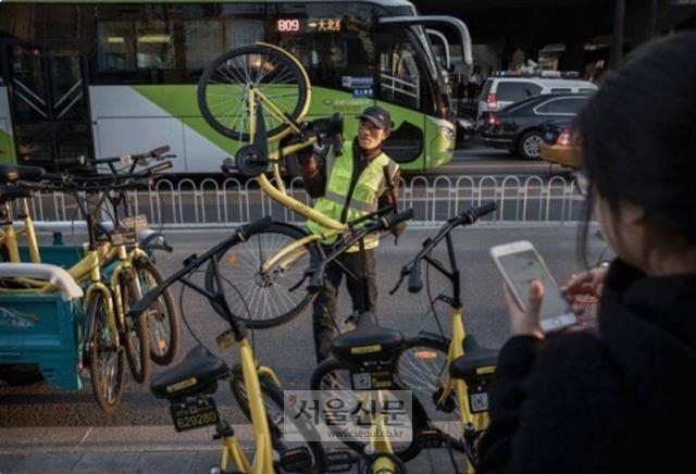한 베이징 시민이 휴대전화를 이용해 오포 공유자전거를 사용하고 있다.