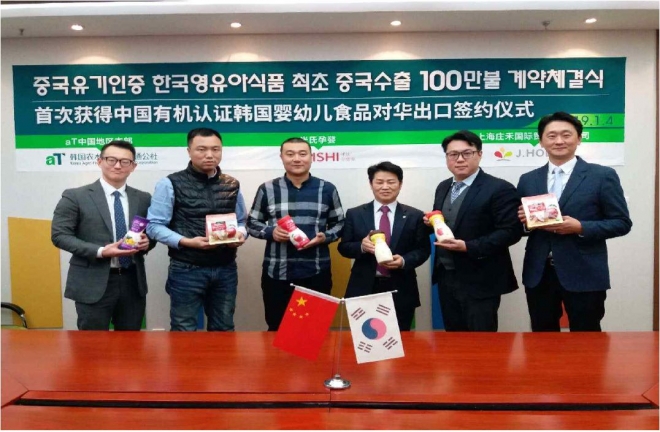 한국 영유아식품의 중국 수출 계약식 참가자들이 손에 중국 유기인증을 받은 한국 제품을 들고 있다. aT제공