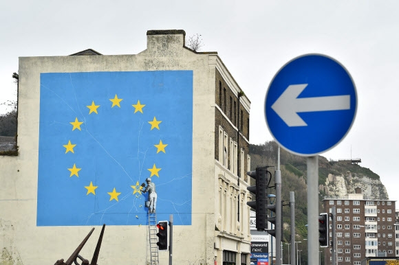 영국 화가 뱅크시가 도버의 한 건물 벽에 그린 유럽연합 국기에서 별 한 개를 쪼아내는 남자 벽화.  도버 AFP 연합뉴스