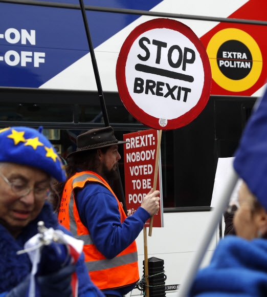 브렉시트(영국의 유럽연합 탈퇴)를 반대하는 한 시위자가 지난 10일(현지시간) 런던 국회의사당 밖에서 ‘브렉시트를 중단하라’고 적힌 피켓을 들고 서 있다.  런던 AP 연합뉴스