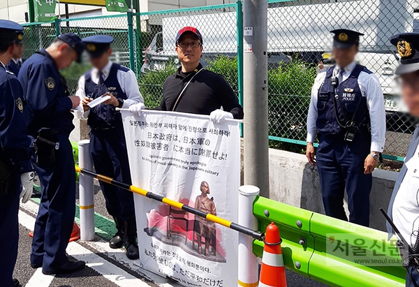 서영근씨가 지난해 4월 12일 주일 한국대사관 앞에서 ‘일본 정부는 위안부 피해자 앞에 진정으로 사죄하라!’고 쓴 피켓을 들고 1인 시위를 하던 중 일본 경찰에 둘러싸여 있다. [사진=서영근씨 제공]