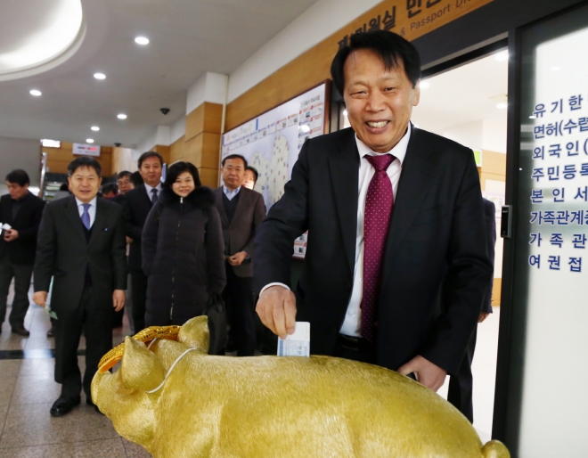 이성(오른쪽) 구로구청장이 16일 구청 1층 로비에서 열린 황금돼지 저금통 제막식에 참석해 성금을 기부하며 환하게 웃고 있다.  구로구 제공 