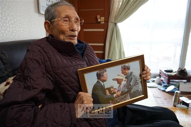 양근방(86) 할아버지가 자택에서 과거 문재인 대통령과 악수했던 사진을 보여 주고 있다. 할아버지는 4·3사건 당시 ‘폭도’라는 누명을 쓰고 10년 넘게 옥살이를 했다.