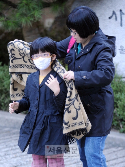 하굣길 마중을 나온 한 학부모가 마스크를 쓴 아이의 목에 목도리를 둘러 주고 있다. 정연호 기자 tpgod@seoul.co.kr