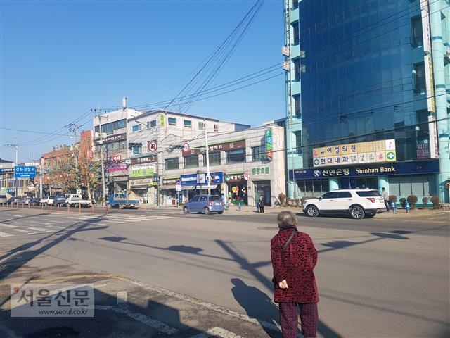 지난달 11일 오전 인천 신한은행 강화지점 맞은편에 위치한 버스 정류장에서 한 노인이 지팡이를 짚고 버스를 기다리고 있다. 썰렁하지만 이곳은 나름 번잡한 강화읍 시내다. 사진 김주연 기자 justina@seoul.co.kr