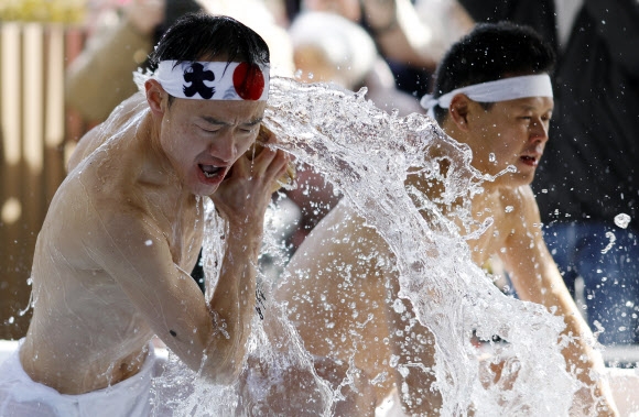 일본 도쿄의 칸다 묘진에서 열린 ‘다이코쿠 축제’ 중 정화 행사를 위해 차가운 물을 쏟아붓고 있다. 마음을 갈고 닦고 정신을 깨끗하게 해준다고 여겨왔던 연례 신년 차가운 목욕 의식에 약 40명이 참가했다. EPA 연합뉴스