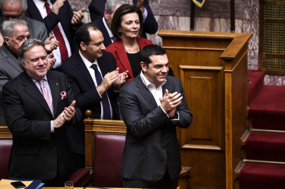 알렉시스 치프라스(오른쪽) 그리스 총리를 비롯한 그리스 의회 의원들이 25일(현지시간) 마케도니아와 체결한 마케도니아 국호 변경 합의안이 의회에서 통과되자 기립 박수를 치고있다.  아테네 AFP 연합뉴스   
