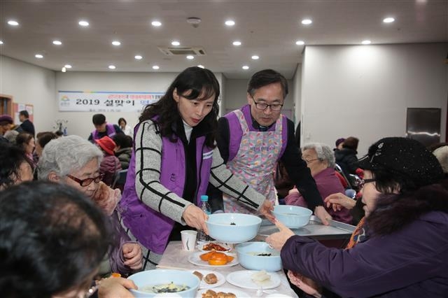 유성훈(오른쪽) 서울 금천구청장이 25일 시흥4동 주민센터에서 열린 설맞이 떡국 나눔 행사에서 노인들에게 떡국을 전달하고 있다. 금천구 제공