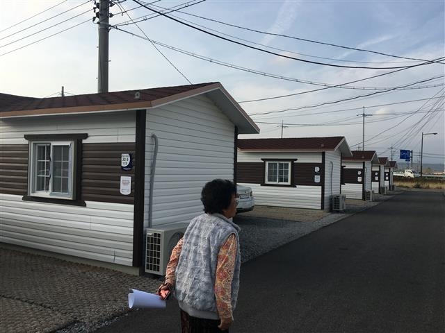 지진 이후 마련된 포항시 북구 흥해읍 희망보금자리 이주단지에 마련된 임시주택을 한 주민이 지나가고 있다.  서울신문 DB