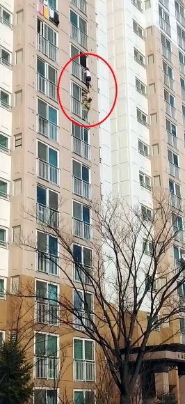 대전 유성구 상대동 한 아파트 9층 베란다에 A(30)씨가 매달려 있는 것을 119구조대원이 구조하고 있다. 연합뉴스