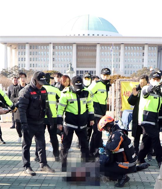 11일 오후 서울 여의도 국회 정문 앞에서 분신을 시도한 택시운전기사가 구급차에 실려 가고 있다. 2019.2.11<br>뉴스1