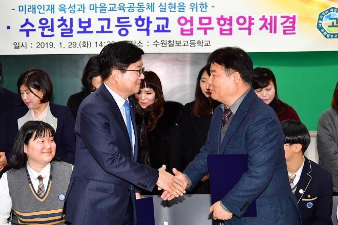 염태영 수원시장(왼쪽)과 김영창 수원칠보고등학교이 학교시설 개방 관련 협약 체결 후 악수하고 있다. 수원시 제공