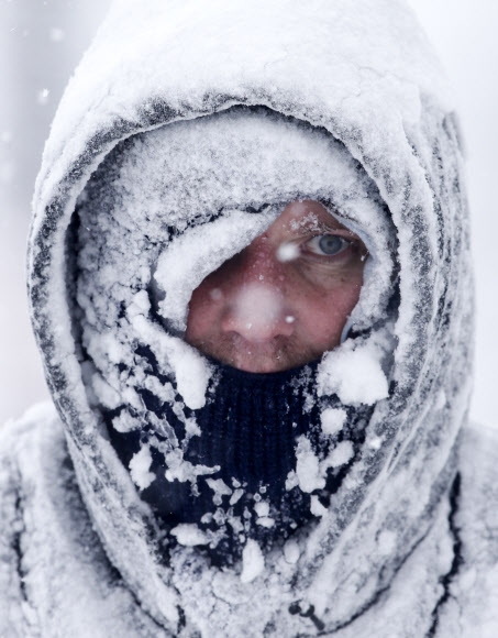 지난 1월 28일 북극진동으로 인해 미국 중북부 위스콘신주 매니토웍에 눈폭풍과 혹한이 몰아친 가운데 한 주민이 집 앞 진입로의 눈을 치우기 위해 나왔다가 눈으로 뒤덮여 얼어붙은 모습. AP연합