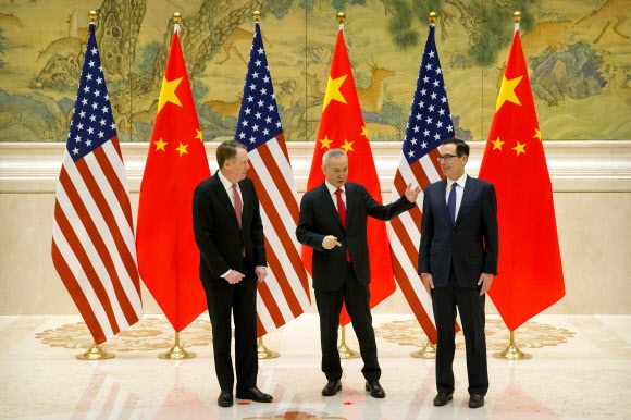 류허(가운데) 중국 부총리가 14일 중국 베이징에서 열린 미중 고위급 무역협상 시작 전 스티븐 므누신(오른쪽) 미국 재무장관과 대화하고 있다.  베이징 로이터 연합뉴스