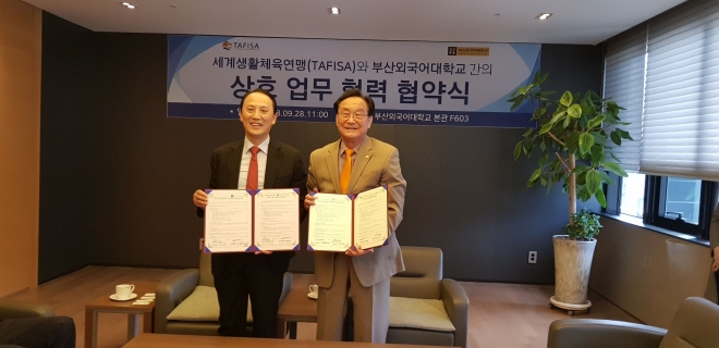 정기영 부산외대 총장(왼쪽)과 장주호 타피사 총재가 부산남산동 캠퍼스에서 최근 상호 업무 협력 협약식을 가진 뒤 귀 기념촬영을 하고 있다.<타피사 코리아 제공> 