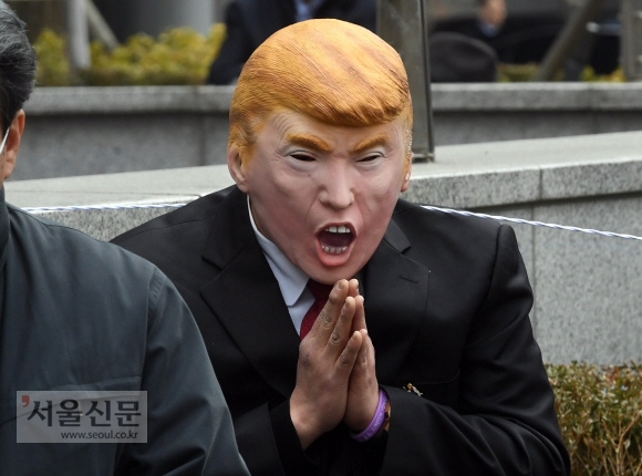 27일 서울 종로구 주한 일본대사관 앞에서 열린  ‘일본군 성노예제 문제 해결을 위한 정기 수요시위’에서 트럼프 대통령 마스크를 쓴 한 참가자가 두손을 모으고 있다. 2019.2.27  정연호 기자 tpgod@seoul.co.kr