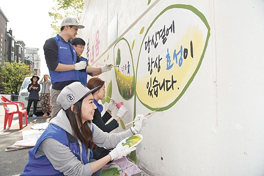 효성 직원들이 협력업체 직원들과 함께 마을 벽화 그리기를 하고 있다.  효성 제공