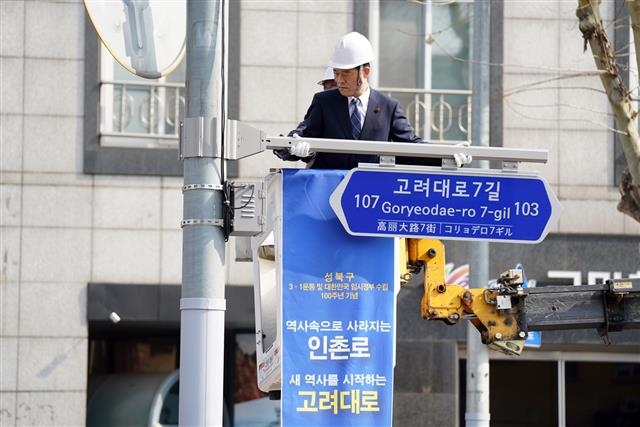 이 구청장이 지난달 27일 구청 바람마당 앞 도로변에서 마지막 남은 ‘인촌로’ 도로명판을 ‘고려대로’로 교체하고 있다.  성북구 제공