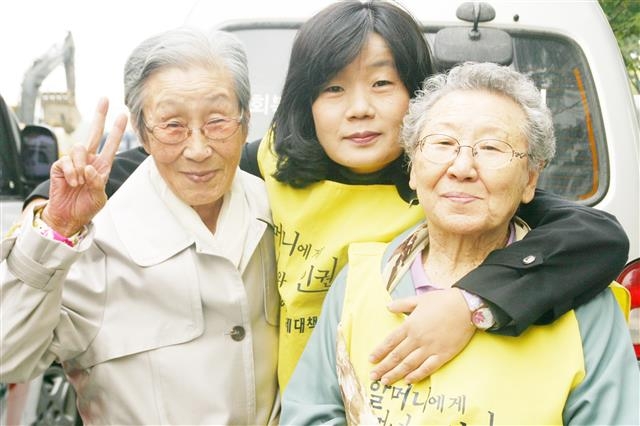2013년 2월 27일 수요시위에서 함께 사진을 찍은 김복동(왼쪽부터) 할머니, 윤미향 정의기억연대 이사장, 길원옥 할머니의 모습.  정의기억연대 제공