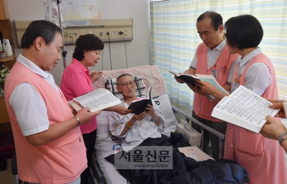 같은 날 병실에서 자원봉사자들이 권씨가 평소에 좋아하는 성가를 부르고 있다. 권씨도 돋보기를 끼고 성가를 따라 부르는 모습이다.   박지환 기자 popocar@seoul.co.kr