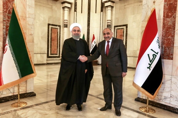 취임 이후 처음으로 이라크를 방문한 하산 로하니(왼쪽) 이란 대통령이 11일(현지시간) 바그다드에서 압델 압둘 메흐디 이라크 총리와 만나 악수하고 있다. 바그다드 AFP 연합뉴스