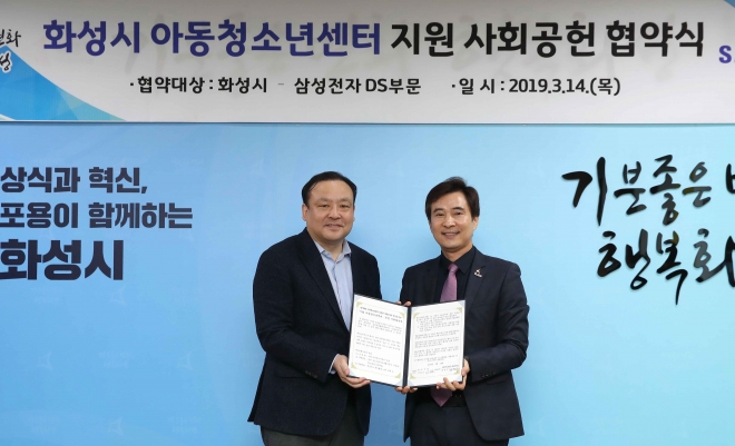 서철모 화성시장(오른쪽)과 최완우 삼성전자 DS부문 사회공헌단장이 14일 ‘시립 아동청소년센터’운영지원 협약을 체결한후 기념촬영을 하고 있다. 화성시 제공. 