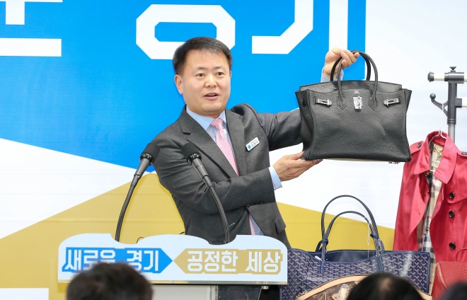 13일 경기도청 브리핑 룸에서 김영수 도 공정특별사법경찰단장이 압수한 짝퉁 명품 가방을 들어보이며 단속 결과를 설명하고 있다. 경기도 제공 