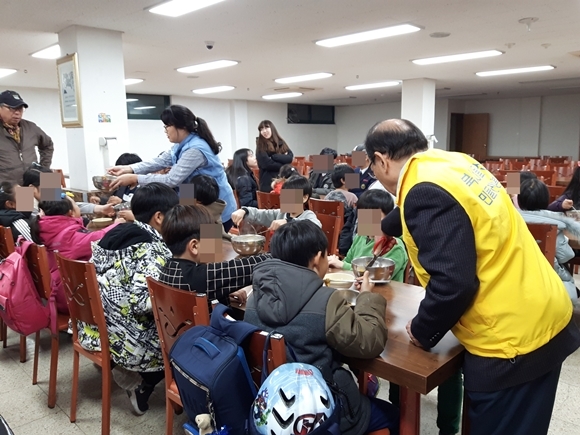 소언섭(오른쪽) 북서울신협 이사장이 최근 서울 도봉구의 한 지역아동센터에서 어린이들에게 짜장면을 잘라주고 있다. 북서울신협 제공