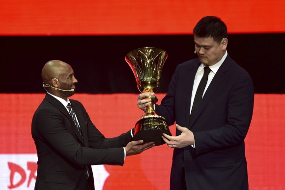코비 브라이언트(왼쪽)가 16일 중국 선전에서 진행된 FIBA 농구월드컵 조 추첨 도중 야오밍 중국농구협회장에게 우승 트로피를 건네고 있다. 선전 AP 연합뉴스 