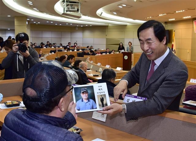 문석진(오른쪽) 서대문구청장이 지난해 11월 구청 대회의실에서 열린 ‘행복 타임머신 작품 전달식’에서 참가 노인에게 추억의 액자와 캐리커처를 전달하며 웃고 있다. 서대문구 제공