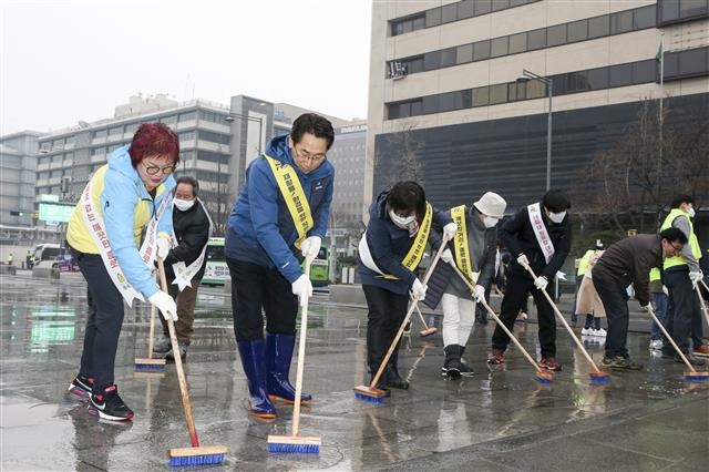 김영종(왼쪽 두 번째) 종로구청장이 지난 20일 구청 직원 및 봉사단체 회원들과 함께 광화문 광장에서 봄맞이 대청소를 하고 있다.  종로구 제공