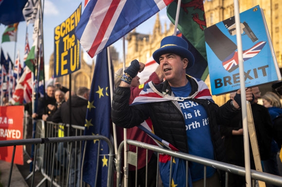 영국의 유럽연합(EU) 탈퇴를 반대하는 시민이 28일(현지시간) 런던 의사당 앞에서 영국 국기를 몸에 두른채 브렉시트 반대 촉구 시위를 벌이고 있다. 런던 EPA 연합뉴스