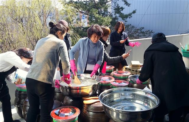 지난달 22일 서울 서대문구 홍은동 서대문문화체육회관에서 열린 서대문장독대 행사에서 주민들이 유기농 메주와 숯, 건고추, 소금물 등을 이용해 장을 담그고 있다.  서대문구 제공