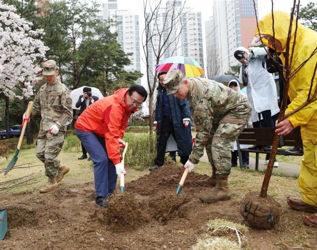 지난해 4월 용산구 당고개 순교성지에서 성장현(가운데) 용산구청장이 식목일을 맞아 미군 장병과 나무를 심고 있다.  용산구 제공