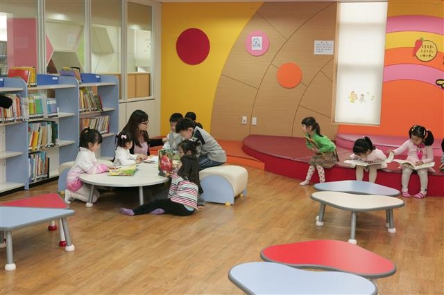 서울 관악구의 한 작은 도서관에서 아이들이 친구들과 어울려 그림책을 읽고 있다.  관악구 제공