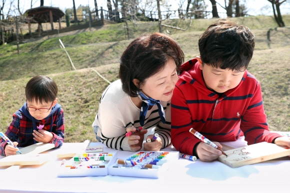 김정숙 여사가 식목일을 하루 앞둔 4일 오전 청와대 경내 유실수단지에서 청와대 인근 초등학교 어린이들을 초청해 꽃나무를 심기전 어린이들과 팻말을 만들고 있다. 2019.4.4   청와대 제공